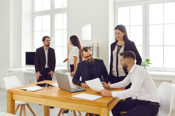 Young people communicating, developing startup ideas, working on projects in creative workspace