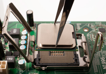 the microprocessor is inserted into the slot on the computer's motherboard using tweezers. isolated...