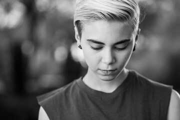 Young woman beauty Tomboy lifestyle with blonde short hair posing in casual clothes in a park in...