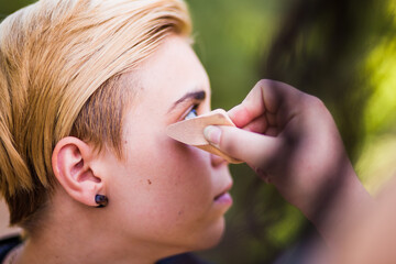 Young woman beauty Tomboy lifestyle with blonde short hair posing in casual clothes in a park in Spain.
Jeans and t-shirt showing armes, gender education and non binary teen.