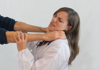 Woman medical doctor attacked with choking grip. Concept of violence and aggression on doctors and healthcare professionals.