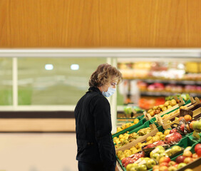 Supermarket shopping, face mask and gloves,Young man buying vegetables and fruits at the market..
