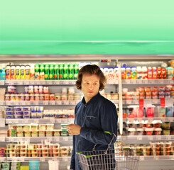 Teenager shopping in supermarket, reading product information