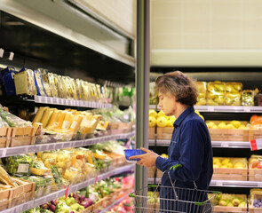 Young man buying vegetables and fruits at the market..