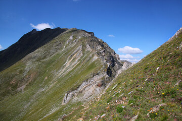 Göflaner Schartl pass and rock formations on a mountain ridge at a hiking trail in the South Tyrol Alps seen from the Martell valley 