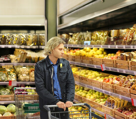 Young man buying vegetables and fruits at the market..