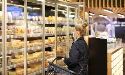supermarket shopping, face mask,Woman choosing a dairy products at supermarket...