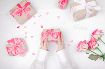 Close up on female hands holding presents for valentine day, birthday, mother's day or christmas. Flat lay