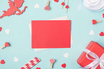Photo of card with place for writing message for lover. Top above close up view photo of red bright card and valentines day accessories on pastel table