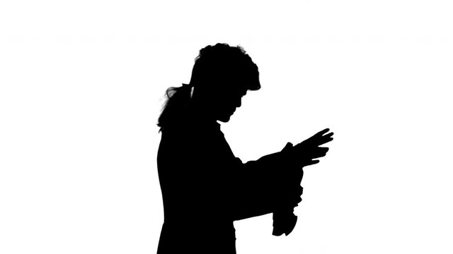 Silhouette Man dressed like Mozart conducting while walking.