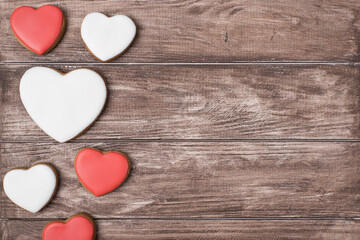 Top flat lay close up view photo of yummy tasty cookies in shape of hearts on brown rustic background