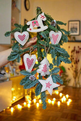 New Year's fir branch with handmade decorations in beige and red colors. with blurry lights in the background. New Year. Christmas. home decor
