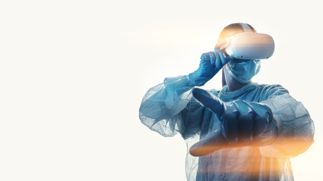 Woman Doctor In A Helmet Of Virtual Reality With Manipulators In Hands On A White Background. The Concept Of Conducting Remote Operations Using Modern VR Technologies