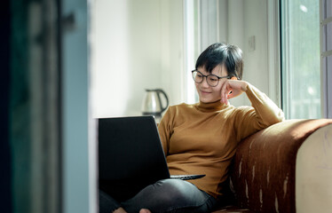 Obraz premium The asian woman chatting with her lover partner by computer notebook at her home on sweet holiday morning.