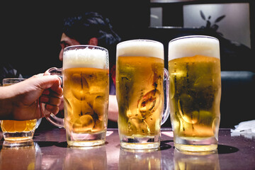 Three big 1 liter beer jars at bar and one hand holding, Tokyo, Japan