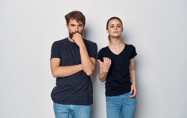 Fototapeta premium cheerful man and woman in black t-shirts studio casual clothes isolated background