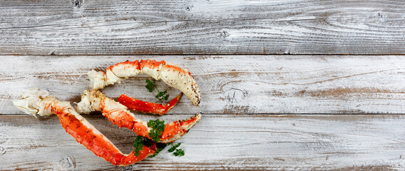 King crab claws on white rustic wood in flat lay format © tab62