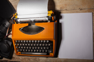 Máquina de escribir vintage con papeles sobre un escritorio de madera rustica. Antiguo equipo o...