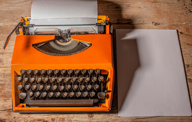 Vintage work office typewriter above rustic escritory. Equipment of journalist and writer. 