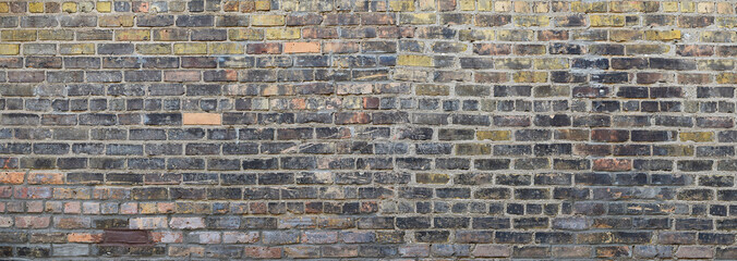 Old grunge mix black, gray, yellow, brown, orange bricks wall background 