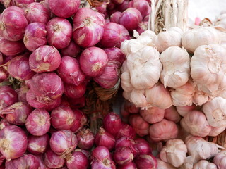 red onion and garlic for sale on market.