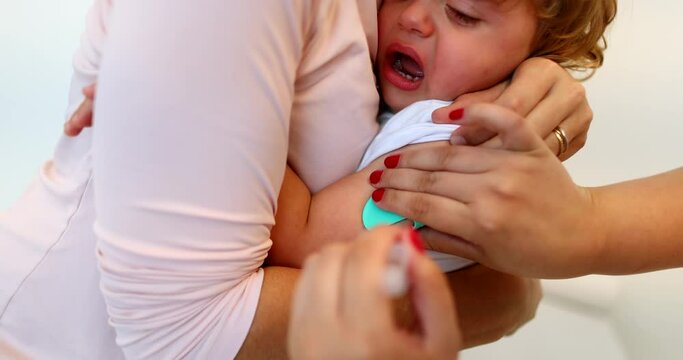 Vaccinating baby toddler. Parent holding infant for vaccination