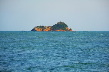 Sleeping lion island in the sea on blue sky background