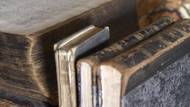 Close-up pan and tilt of worn ancient books with map in background