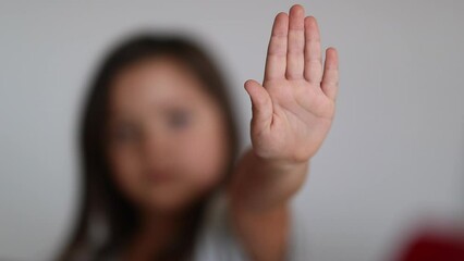Little girl signalling to STOP with hand