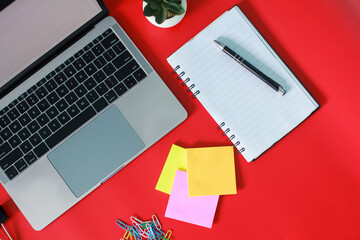 Flat lay top view of stylish home office with laptop, book, sticky note and accessories isolated on...