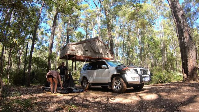 Time lapse of Australian couple unfolding a rooftop tent in campsite in a campsite in a forest in Western Australia.In 2018 over 6.9 million overnight camping trips were made.