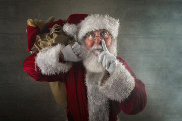 Santa Claus laying a finger aside of his nose in the chimney