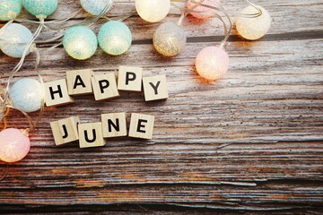 Happy June alphabet letter with LED Cotton ball Decoration on wooden background