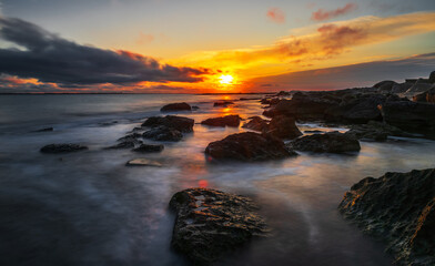 Rocky sea coast at sunrise, long exposure