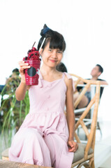 Close up Fresh mixed berry smoothie in Clear glass with blur image of woman holding. Fruit that nourishes the eyes. 