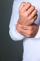  Young man in suffering wrist pain, close up 