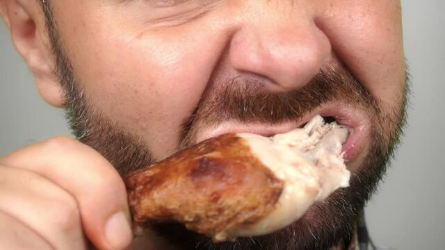 close-up, a man eating a fried chicken leg. Unhealthy food. Home delivery. slow motion FullHD footage