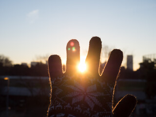 This is a picture of the rising sun seen through gloves on a winter morning. I feel the cold air in the morning.