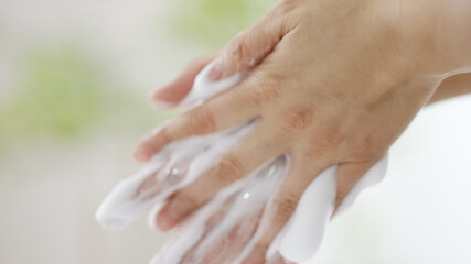 石鹸で手を洗う女性