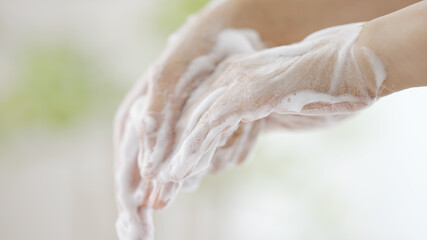 石鹸で手を洗う女性