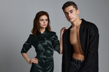 Woman dress and sexy man in jacket on gray background cropped view