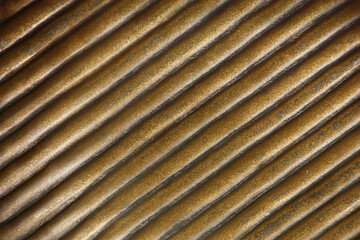 Ceramic tile with a ridge surface. Edges on the image are located on diagonal. The surface is processed by golden paint and made old.