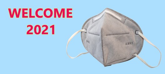 KN95 or N95 mask for protection pm 2.5 and corona virus (COVID-19).Anti pollution mask.air face mask on blue background with "welcome 2021" word.