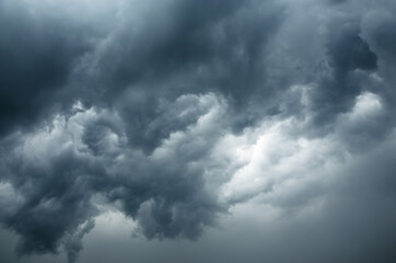 Background of dark stormy ominous clouds in gray moody sky
