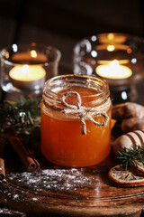 A jar of honey among Christmas decorations.