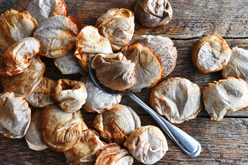 A close up image of a used wet tea bag resting on a spoon. 