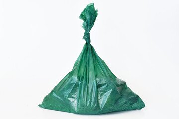 A close up image of large green dog poop bags on a white background. 
