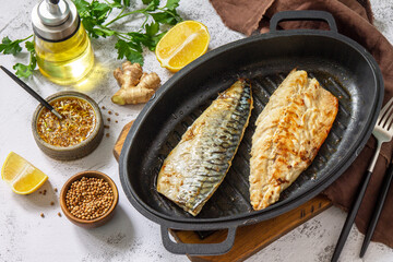 Grilled baked mackerel with ginger mustard honey sauce on a marble table top.