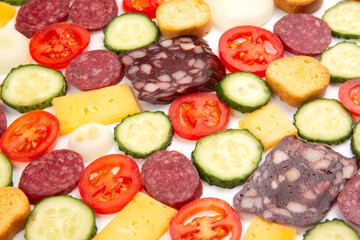 sliced ​​pieces of sausage, salami, cheese, cucumber and tomato. fast food. ingredients for pizza. calories and diet