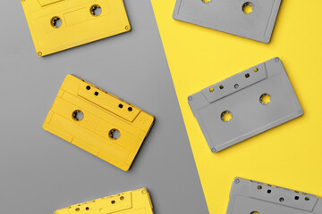 Audio cassettes on gray and yellow background top view
